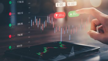 Stock exchange market concept, hand touching on trading icon screen with graphs analysis candle line on bokeh colors light.